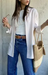 Camisa beige con rayas verticales blancas, de corte holgado y largo a la cadera.