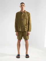 Short de hombre de corte relajado, confeccionado en lino de alto gramaje. Presenta cintura elástica con cordón ajustable, bolsillos laterales y un bolsillo trasero.