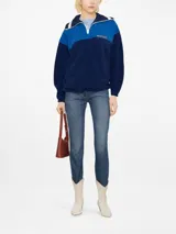 Buzo polar deportivo azul marino y celeste con cuello polo y cierre de cremallera parcial.