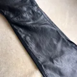 Pantalón de cuero vacuno negro, de tiro alto y corte recto con aberturas laterales en los bajos.