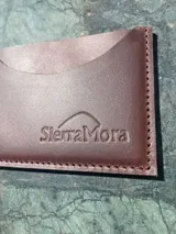 Tarjetero de cuero con diseño animal print en el frente y cuero liso marrón oscuro en la parte posterior, con compartimentos para tarjetas en ambos lados.