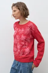 Sweater de punto color rojo con cuello redondo, mangas largas y bordado floral en tono rosado en la parte frontal.
