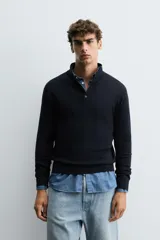 Jersey de punto de lana con ajuste regular, cuello subido y cierre frontal con botonadura. Presenta manga larga y acabados en rib en puños y ruedo.