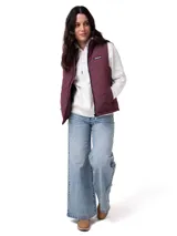 Chaleco acolchado color violeta con diseño de costuras en zigzag. Cuenta con cierre frontal central, cuello alto, bolsillos laterales con cierre y forro interno con logo estampado. Presenta tecnología resistente al viento y al agua con aislamiento térmico reciclado.