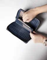 Billetera azul de cuero vacuno con cierre perimetral, múltiples espacios para tarjetas, espacio para billetes y monedero con cierre incorporado.