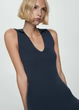 Vestido largo de punto fino color azul oscuro, con diseño entallado, cuello polo y sin mangas. Presenta una abertura posterior en el bajo.