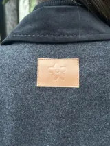 Tapado gris con detalles en pana negra en cuello, solapas, hombros y bolsillos.