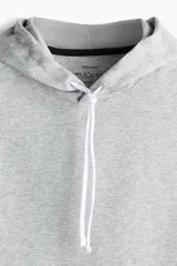 Buzo deportivo sin mangas color gris, confeccionado en tejido funcional DryMove™ que ayuda a absorber el sudor. Cuenta con capucha forrada en malla con cordón ajustable, corte estándar y bajo recto con aberturas laterales.