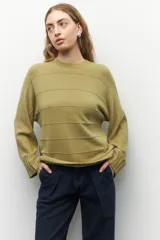 Sweater gris tramado de mangas acampanadas y cuello a la base.