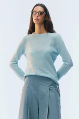 Sweater de tejido fino color celeste, con corte al cuerpo, mangas largas y escote redondo.