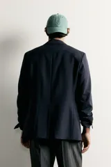 Blazer cruzada Zara para hombre, corte relaxed fit, de color azul marino con botones dorados metálicos. Presenta cuello con solapas de pico, bolsillos con solapa en la cadera y bolsillo de vivo en el pecho.