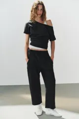 Pantalón de algodón negro con tiro medio, cintura elástica, pierna recta y grandes bolsillos laterales aplicados.