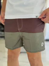 Short de baño con diseño bicolor en tonos gris y rosado, con costuras decorativas visibles en contraste y pequeño aplique circular en el lateral.