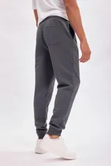 Pantalón tipo jogger de corte deportivo, color gris oscuro, con cintura elástica y puños ajustados en los tobillos.