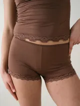 Micro short de tiro bajo color marrón, confeccionado en microfibra con delicado detalle de encaje en las piernas.