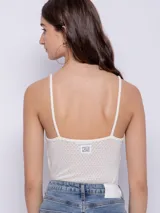 Musculosa blanca de tela texturada con tirantes finos.