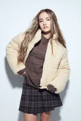 Campera puffer de corderito negro con cuello alto y diseño oversized. Presenta una textura tipo teddy, cierre frontal y corte a la cintura.