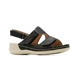 Sandalia casual de cuero sintético color beige, con tiras ajustables con velcro, plantilla de cuero y suela baja con plataforma leve. Presenta detalles de perforaciones florales en una de las tiras.