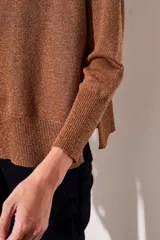 Sweater color cobre con lurex, de corte holgado y mangas largas.