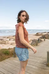 Musculosa tejida en punto calado, color violeta, con diseño sin mangas y detalle de flecos en los hombros.
