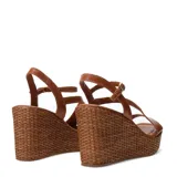 Sandalias de plataforma de corcho trenzado y taco chino, color suela, con tiras cruzadas de cuero y cierre de hebilla en el tobillo.