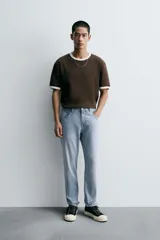 Pantalón de jean corte slim fit, color gris con efecto lavado. Presenta diseño de cinco bolsillos, cierre frontal con cremallera y botón, y tejido elástico.