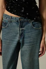 Pantalon de jean de corte ancho y tiro bajo, con diseño de pierna recta y acabado en tono azul medio.