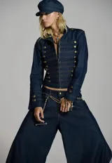 Chaqueta de jean Karech de corte entallado y estilo napoleónico, confeccionada en denim azul. Cuenta con cierre frontal con cremallera, cuello mao y detalles de alamares horizontales con botones dorados metálicos.