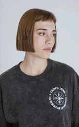 Remera negra con efecto nevado, corte oversize, mangas cortas y cuello redondo. Estampado en la espalda con diseño de una figura femenina y la frase 'Chill Bitch Trust Karma - The Wheel of Fortune'.