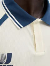 Camiseta tipo polo de manga corta con calce holgado, confeccionada en tejido liviano y flexible. Presenta cuello clásico, detalles en contraste y estampados gráficos en el frente con estilo deportivo.