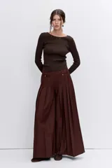 Pantalon de vestir color marron, de corte ancho y tiro alto, con diseño plisado y detalles de bolsillos frontales con botones.
