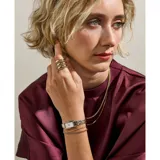 Reloj de pulsera Skagen con caja rectangular de acero inoxidable en tono dorado y esfera blanca minimalista. Presenta una malla metálica de eslabones combinados en plateado y dorado, con mecanismo de cuarzo de dos agujas.