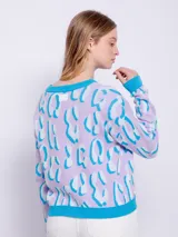 Sweater de punto amarillo con estampado animal print rosa, de manga larga y cuello redondo.