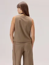 Chaleco negro sin mangas, de corte recto y largo a la cintura, con cuello redondo y cierre frontal oculto.