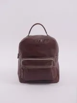 Mochila de cuero natural color marrón, con diseño clásico y refinado. Cuenta con un compartimento principal con cierre, dos bolsillos frontales con cierre y un bolsillo trasero. Incluye manija superior, correas ajustables y aplique trasero para sujetar a equipaje.