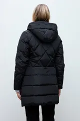 Campera acolchada de corte largo con diseño capitoneado en forma de rombos, cierre frontal con cremallera y capucha integrada.