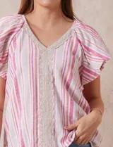 Blusa Cupio de lino estampado a rayas rosas y blancas, con escote en V y aplique de crochet en el frente. Tiene mangas cortas amplias.