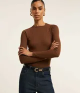 Blusa de manga larga con diseño ajustado, confeccionada en tejido acanalado de viscosa con elastano. Presenta cuello redondo y sisas raglán.