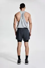 Short deportivo gris con calza interior negra, corte estándar, con cintura elástica y cordón ajustable.