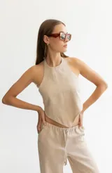 Pantalón color beige de lino, con elástico y tira ajustable en la cintura, bolsillos a ambos lados y pata de elefante estilo Oxford.