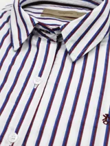 Camisa de manga larga a rayas verticales celestes y blancas, de corte suelto, confeccionada en algodón.