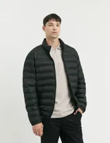 Campera capitoneada de poliéster con cierre frontal al tono y bolsillos laterales con cierre invisible.