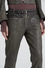 Pantalón de cuero color gris con tiro bajo, bolsillos delanteros con labio y cierre metálico oculto, pierna con recortes en delantero y pinza en espalda.
