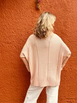 Polera de tejido de punto con diseño de ochos, color rosa viejo, de corte oversize y cuello alto, con mangas largas y puños acanalados.