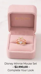 Set de tres anillos apilables de plata 925 con baño de oro. Incluye un anillo con dije de corazón pavé de circonias, un anillo con esmalte rosa y detalles de corazones, y un anillo con diseño de lazo de Minnie Mouse decorado con circonias.