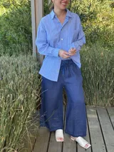 Pantalón capri azul marino de lino, con corte ancho, cintura elastizada ajustable con cordón y terminación con flecos.