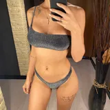 Conjunto de bikini de dos piezas color plateado brillante, con corpiño de un solo hombro y bombacha cavada.