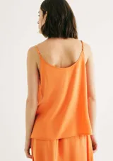 Camiseta sin mangas de corte regular en tono melocotón, con tirantes finos, escote en V y detalle de botones decorativos en el centro del pecho.