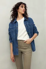 Pantalón chupín de tiro medio con textura similar al denim, en color beige claro.