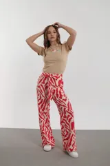 Pantalón de vestir de corte palazzo con estampado abstracto en color rojo y beige, con lazo en la cintura.